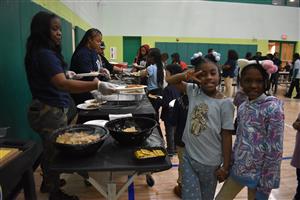 students standing in front servers for nacho toppings
